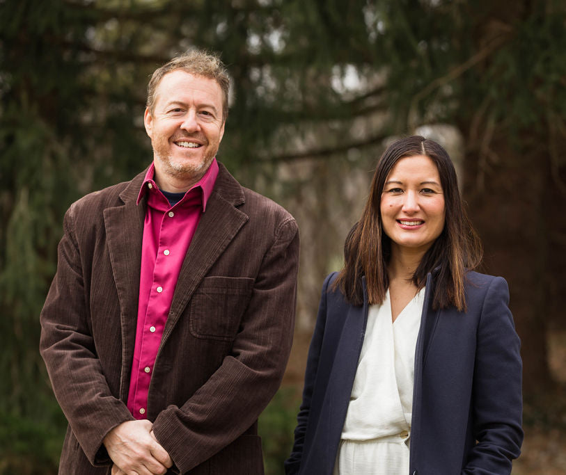 Two Doctors standing outdoors with trees in the background